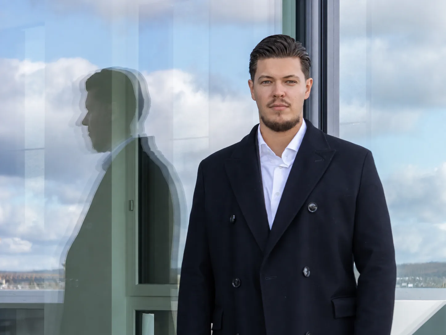 Cedrik Leibinn am Panoramafenster der Kanzleiräume